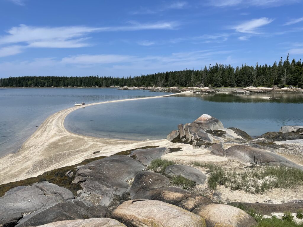 Sandbar extends between rocks in Seal Bay Vinalhaven Maine.