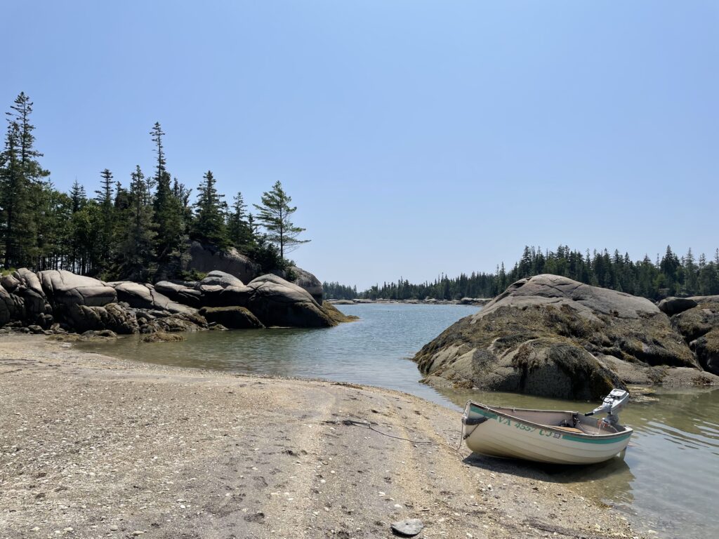 A dinghy sits on a low tide beach at the Seal Bay anchorage, Vinalhaven, Maine.